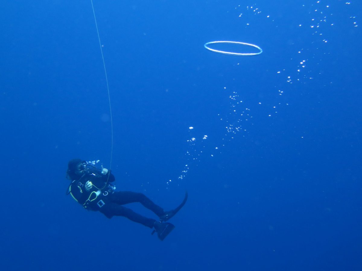 diver floats and plays with regulator bubbles