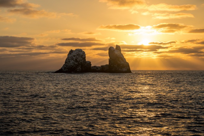 a warm sunset shining on roca partida, the split rock